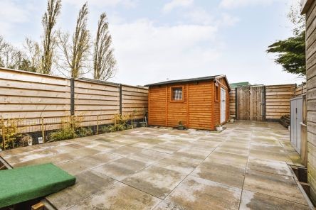 Transformed backyard with spacious patio area, wooden fencing, and organized storage units in Burbank home