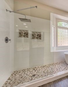 Custom tile installation in Tujunga home bathroom featuring textured pebble shower floor, white subway tile walls, and contemporary fixtures