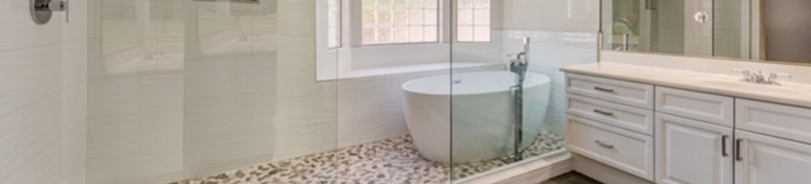 Luxury master bathroom remodel in Tujunga featuring custom walk-in shower with pebble stone floor, freestanding soaking tub, and modern white cabinetry